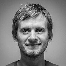 Black and white headshot of a young man smiling.