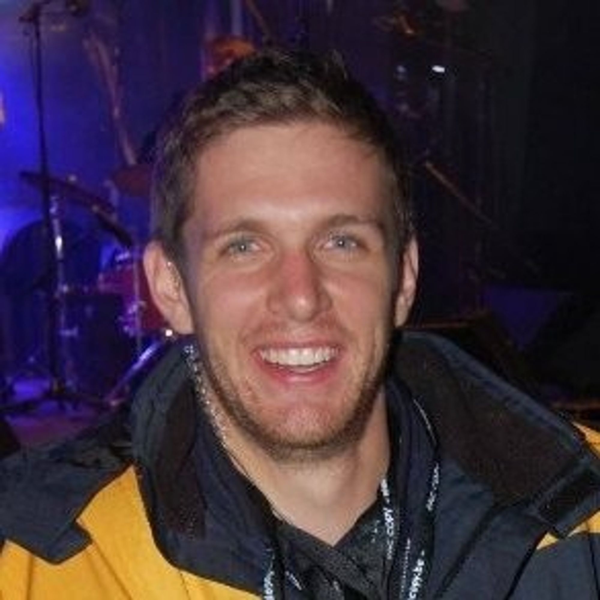 Image of a man wearing a ski jacket and smiling at the camera.
